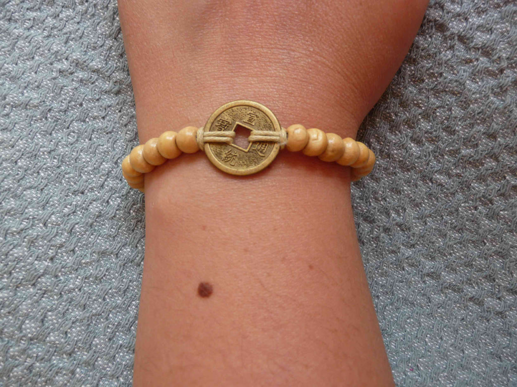 BRACELET BEIGE EN PERLES DE BOIS ET PIÈCE CHINOISE