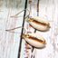 Boucles d'oreilles dorées pendantes en coquillages cauris