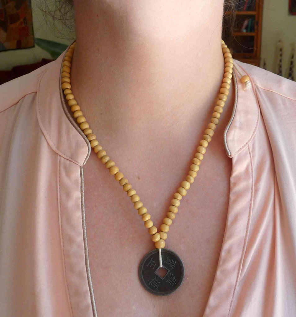 Collier en perles de bois et pièce chinoise