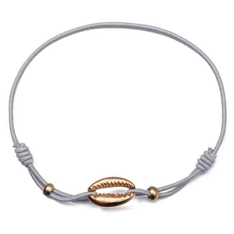 Bracelet fine chaîne dorée avec coquillage cauris blanc et doré