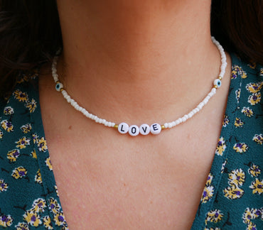Collier LOVE en perles blanches et oeil porte bonheur