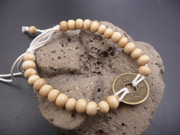 Bracelet feng shui beige en perles de bois et pièce chinoise porte bonheur