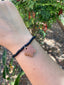 Bracelet en perles rondelles Heishi noires et fleur en terre cuite