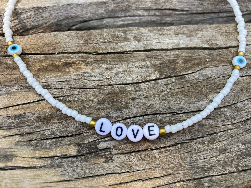 Collier LOVE en perles blanches et oeil porte bonheur