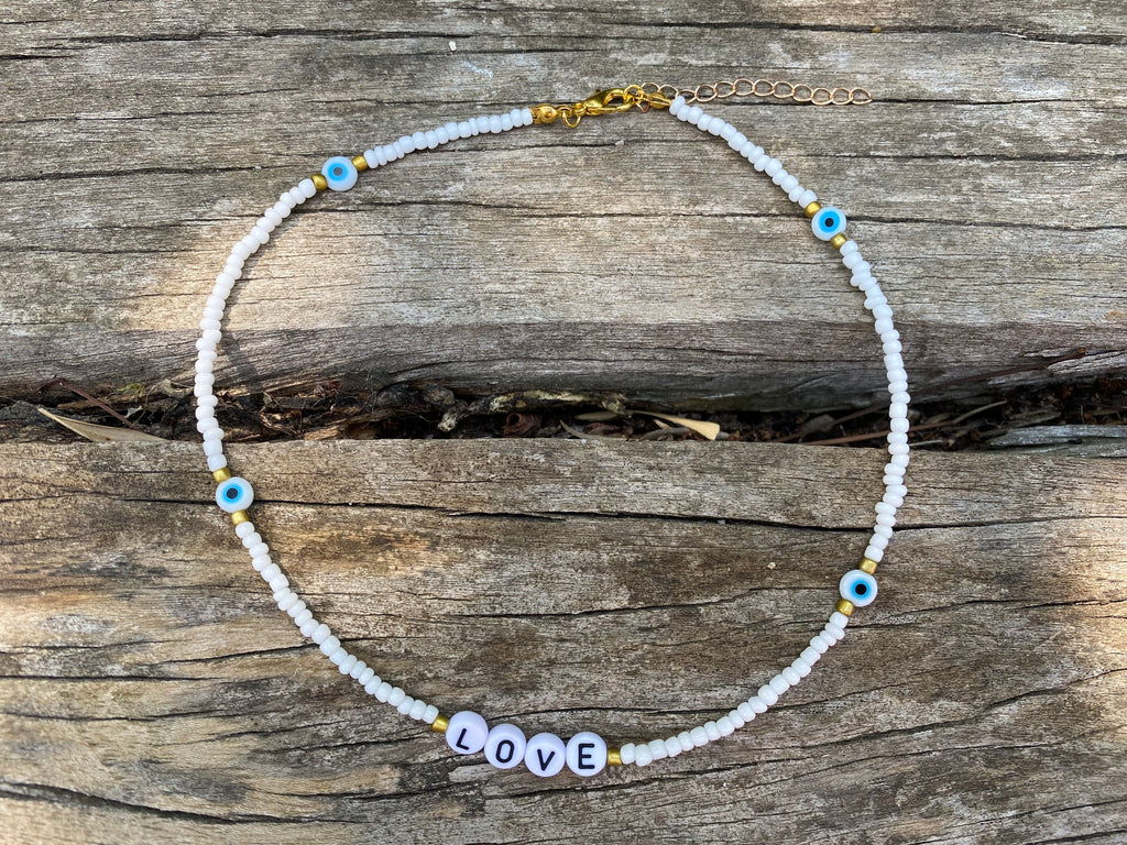 Collier LOVE en perles blanches et oeil porte bonheur